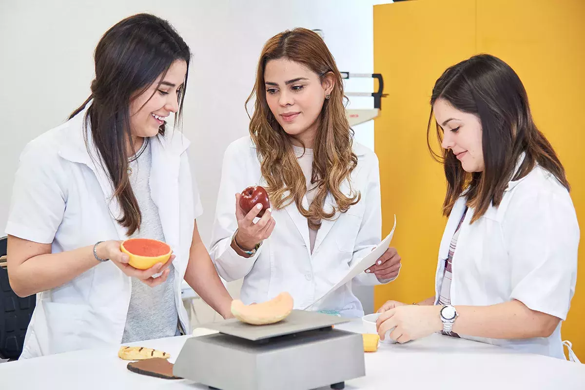 Alumnas interactuando con alimentos.