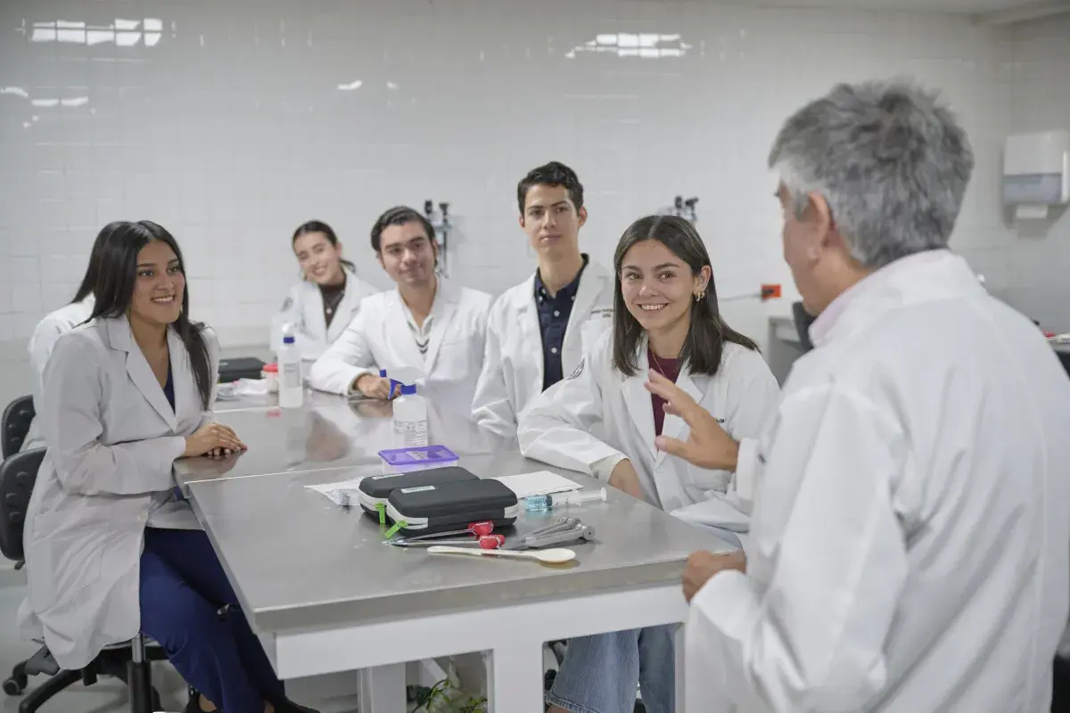 Alumna con estetoscopio revisando al paciente.