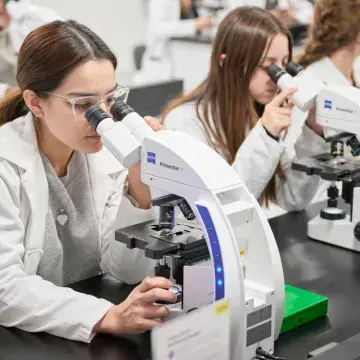 Alumna viendo en el microscopio.